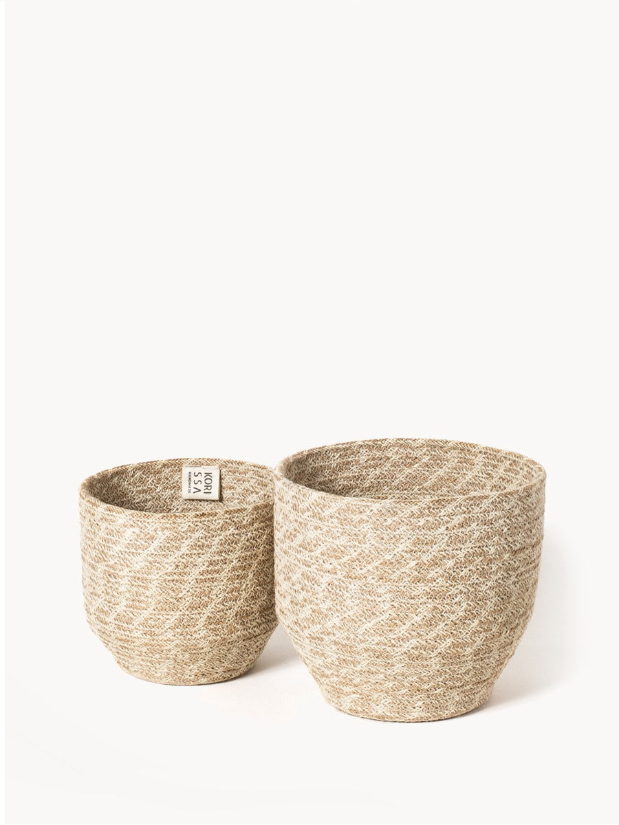 Set of two woven jute storage bins in natural tan, cylindrical plant baskets with textured weave pattern