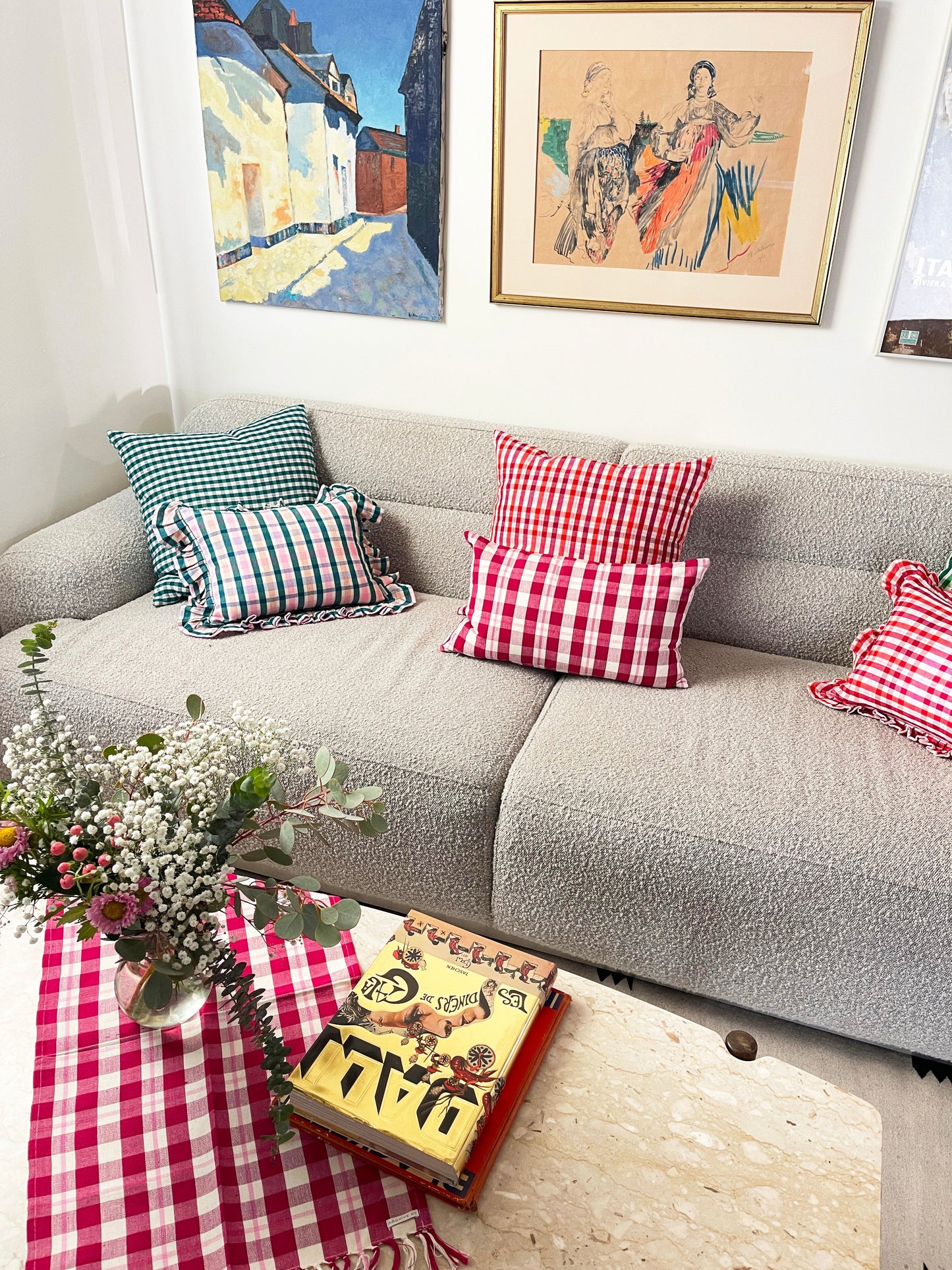 Teal and white striped linen pillow with ruffled edge, displayed on gray sofa with coordinating plaid pillows