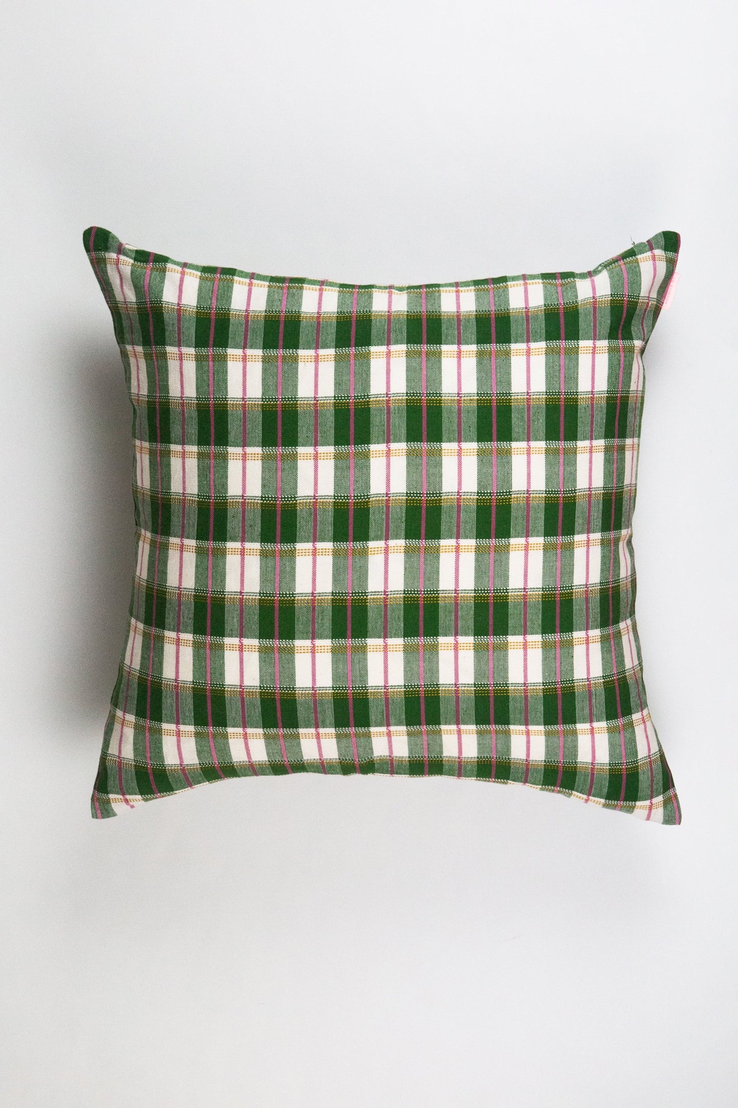 Green and white plaid throw pillow with red stripe accents and woven cotton texture