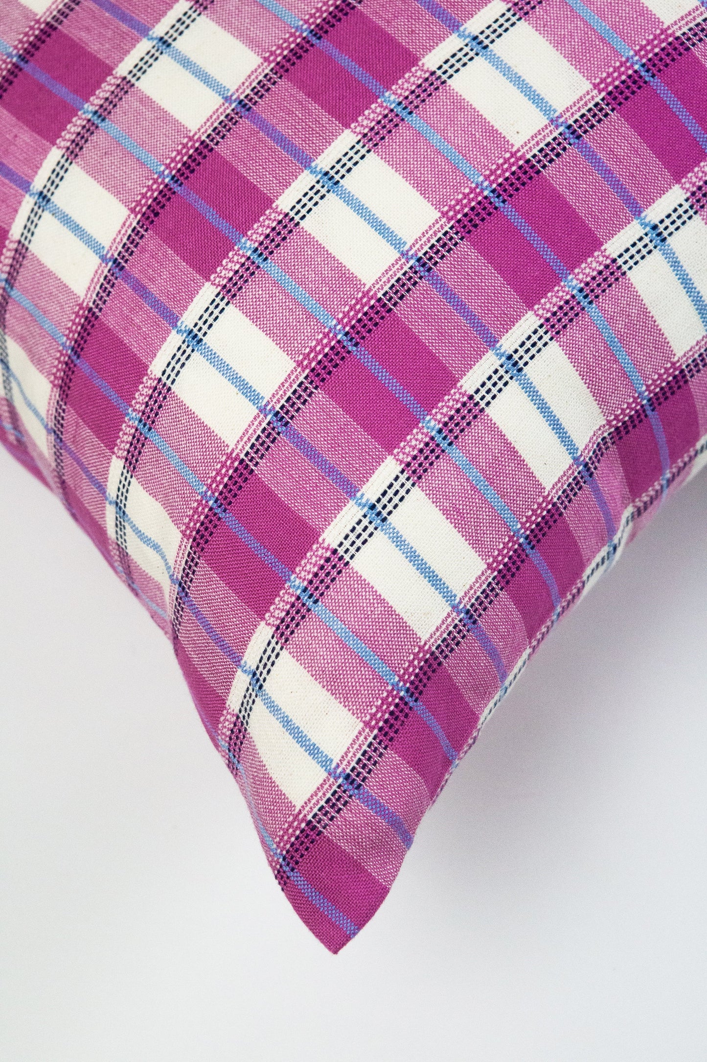 Pink gingham plaid linen pillow with white, purple, and blue woven stripes and textured fabric weave
