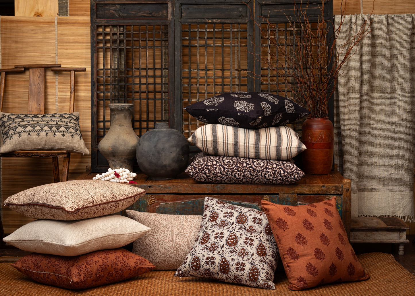 Black linen decorative pillow with white paisley print pattern displayed in styled home setting