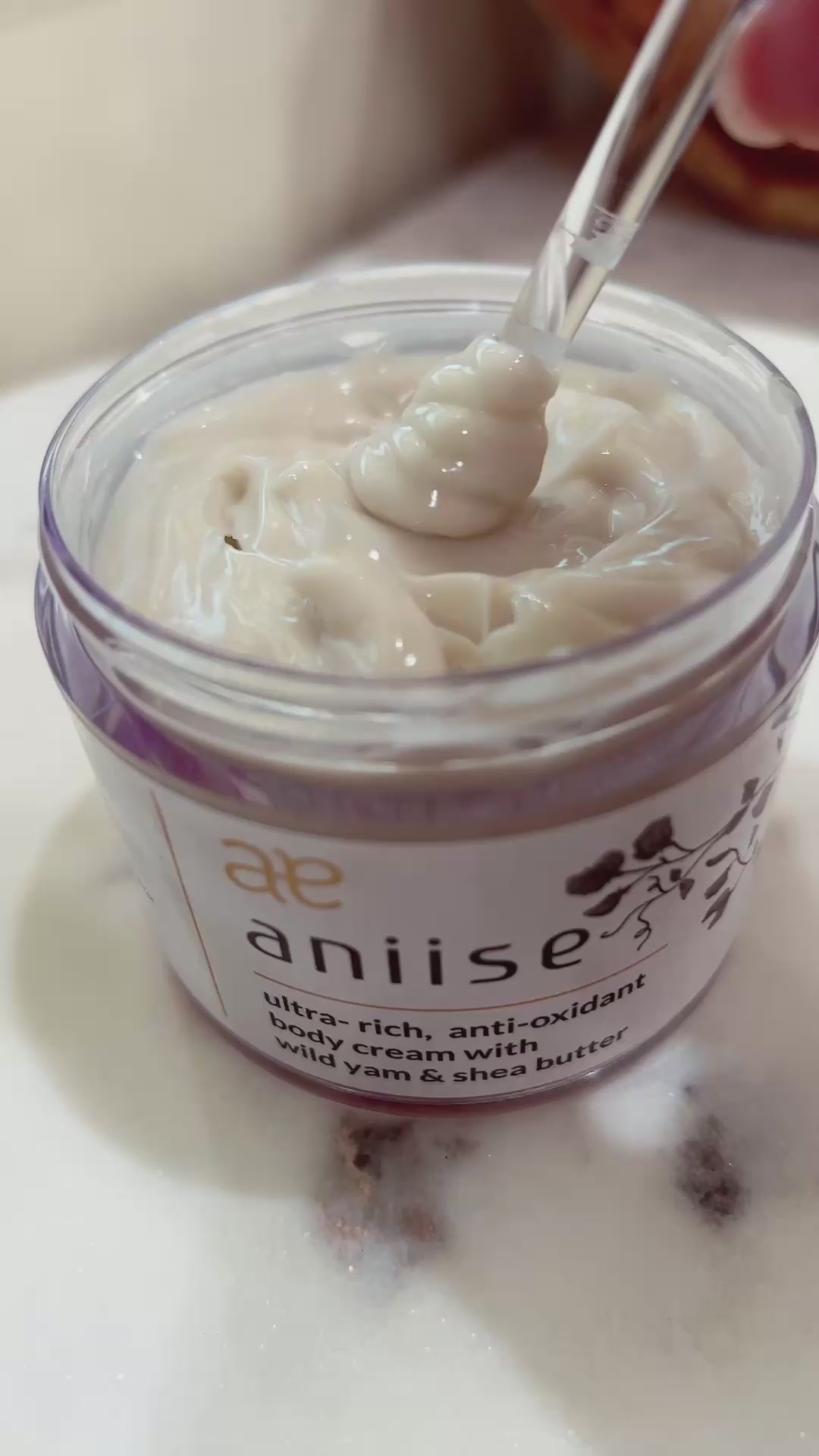 Ultra-rich cream body moisturizer with wild yam and shea butter in glass jar with spatula