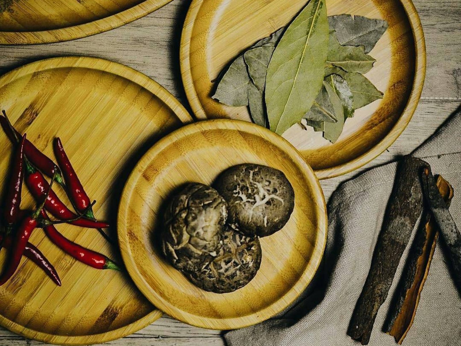 Bamboo round platter with natural wood grain texture, holding herbs and spices, sustainable serveware