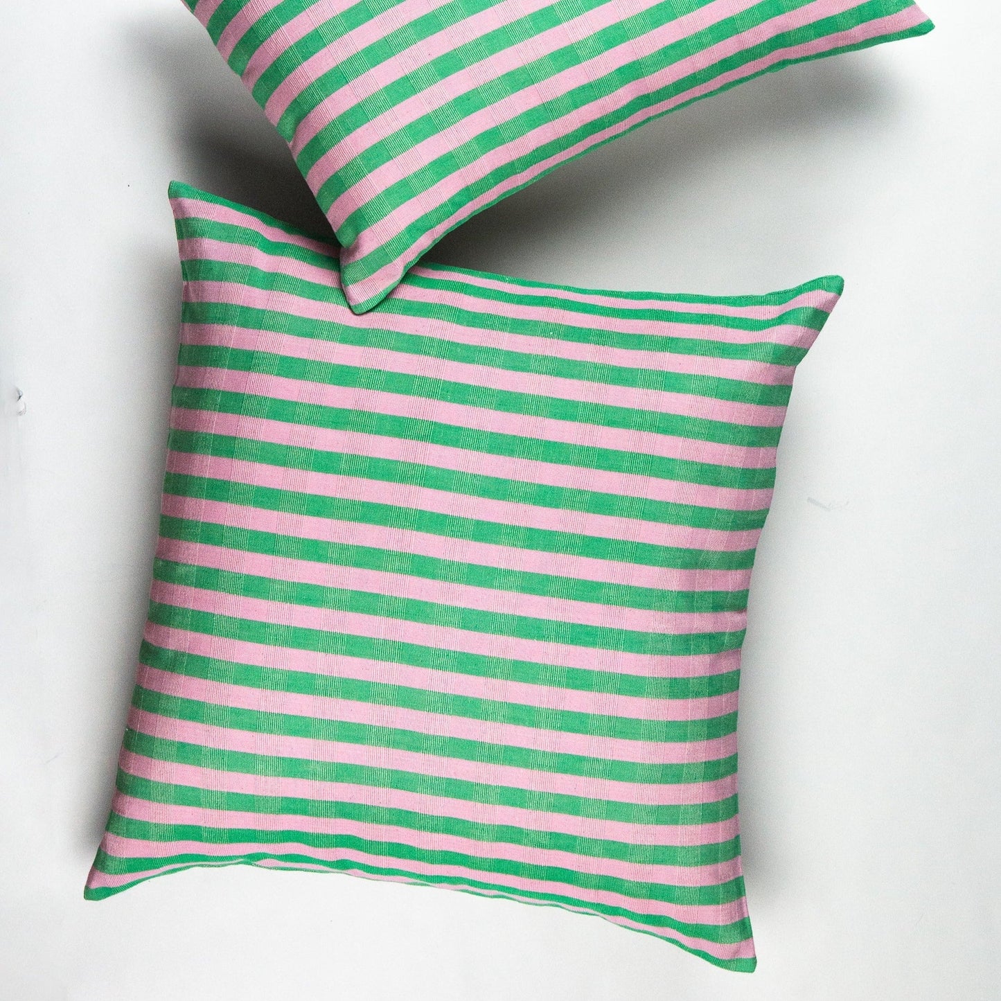 Green and pink striped organic cotton pillow with bold horizontal pattern and soft knit texture