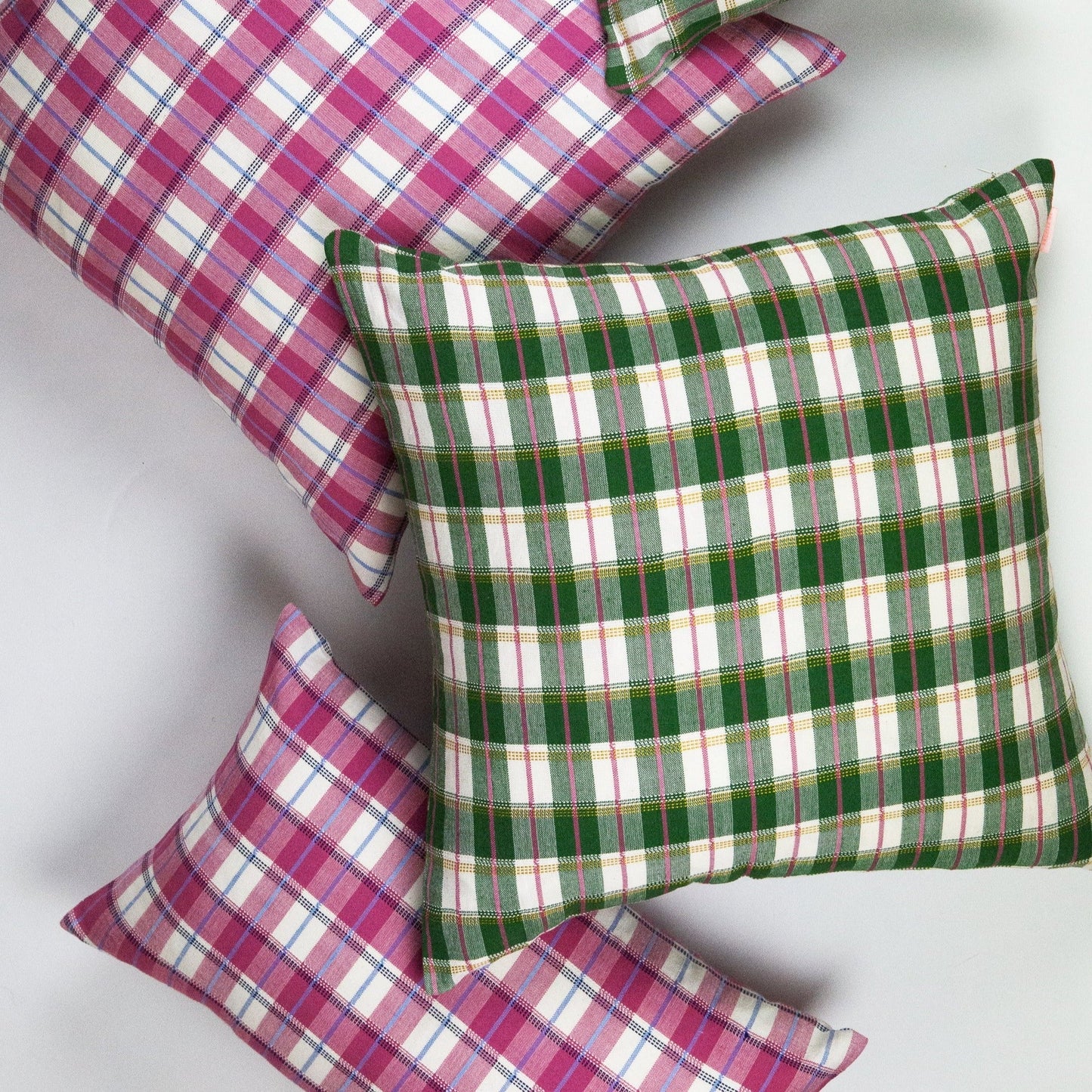 Gingham plaid pillows in magenta and green with white stripes, woven textile bedding accent