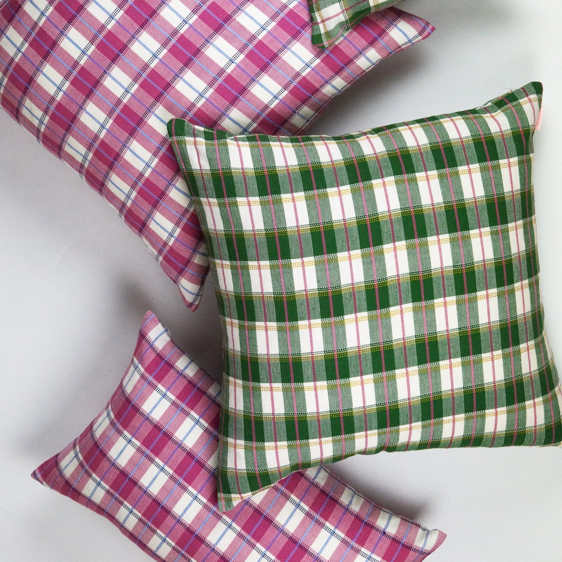 Gingham plaid pillows in magenta and green with white stripes, woven textile bedding accent