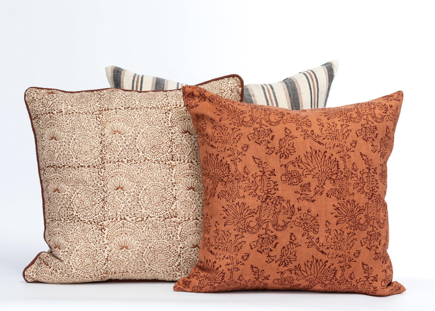 Rust and cream floral print decorative pillow covers with botanical patterns and piped edges