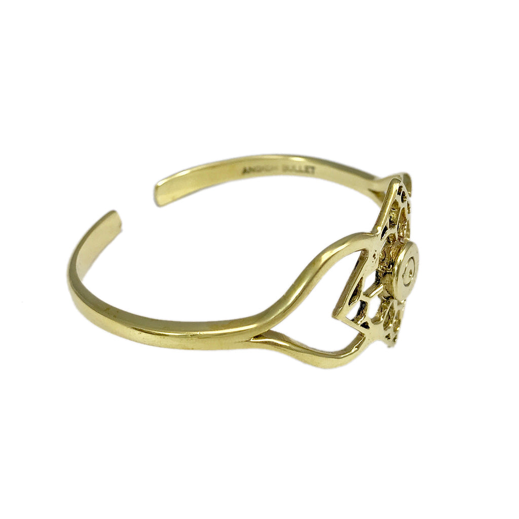 Polished brass cuff bracelet with ornate geometric medallion accent detail and curved open design