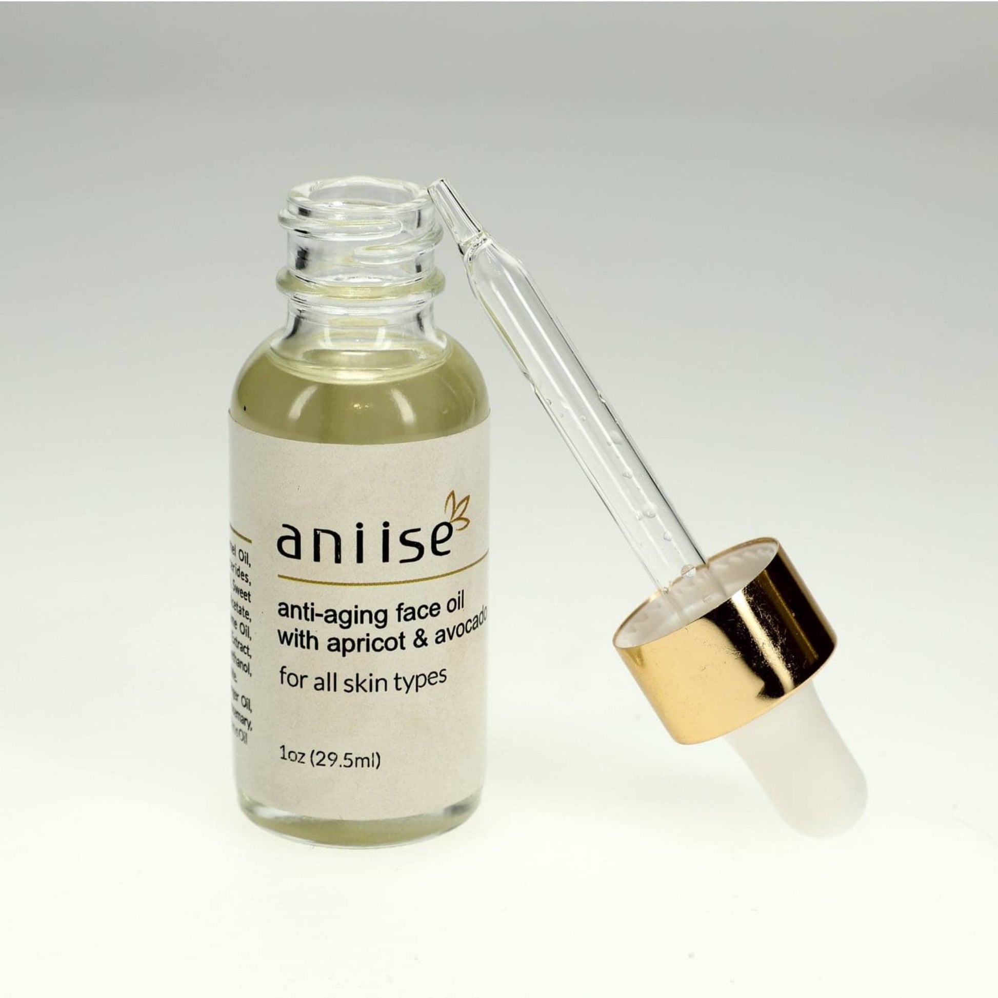Anti-aging face oil with apricot and avocado in clear glass bottle with gold dropper cap