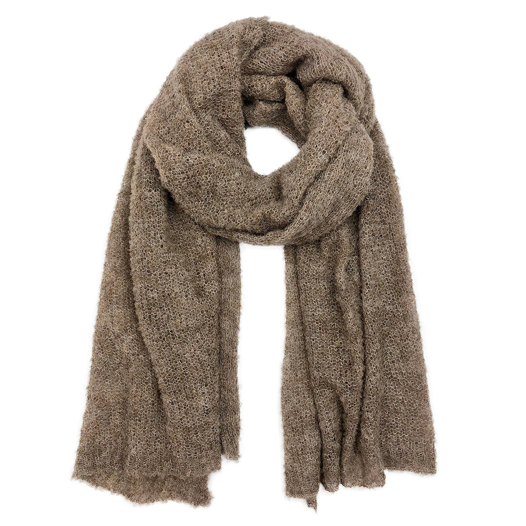 Beige knit alpaca scarf with soft textured weave and frayed edges, draped accessory style