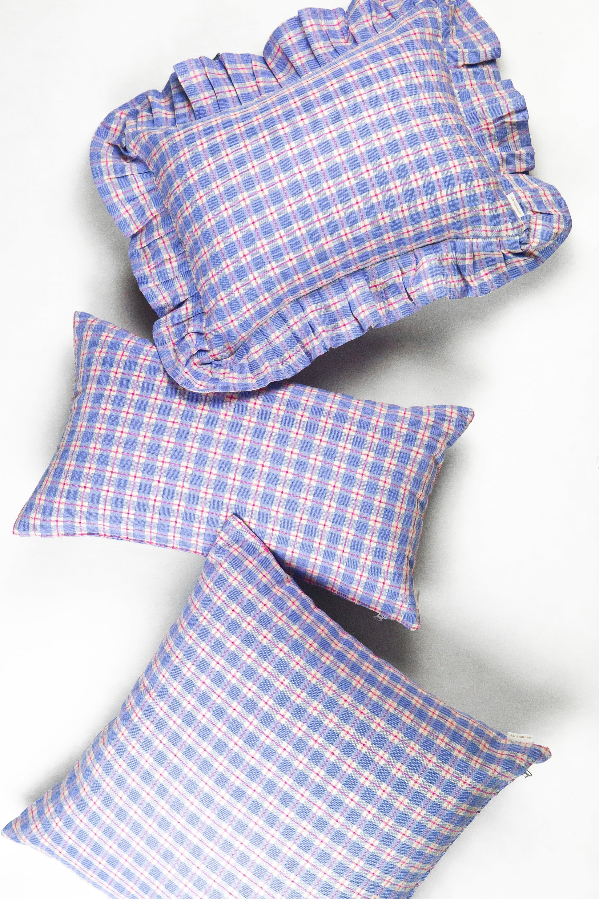 Blue and pink plaid bedding set with ruffled duvet cover and matching rectangular pillows, cotton blend textile