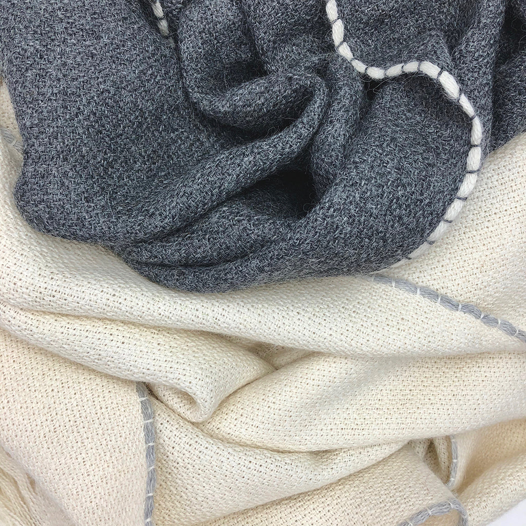 Charcoal and cream baby alpaca scarves with contrast stitching, soft knit texture and lightweight wrap style