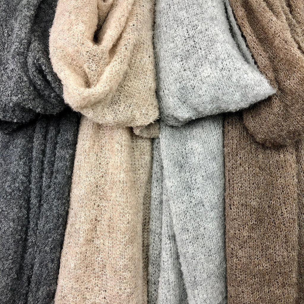 Ultra plush alpaca scarves in neutral earth tones including charcoal, cream, gray, and brown with soft textured fabric