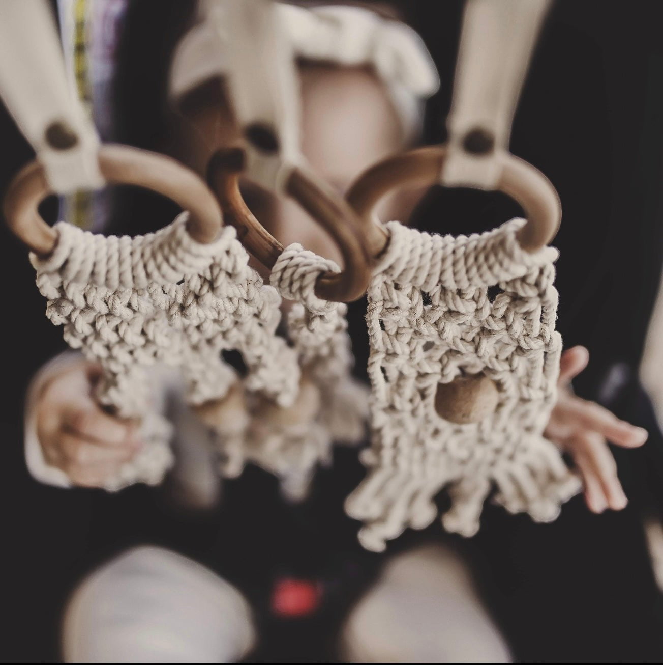 Cream macrame baby toy set with wooden rings and textured knotted fabric detail, sustainable children's toy